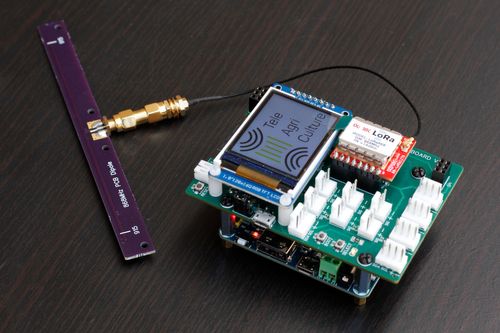 a circuit board with a display, an antenna and a bunch of connectors, the display reads "TeleAgriCulture"